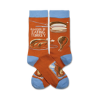 Pair of crew socks in orange and light blue. The socks feature a Thanksgiving-themed design with a roasted turkey and the text 'I'd Rather Be Eating Turkey'.