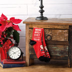 Lifestyle product shot showing the socks on a wooden side table next to a poinsettia and clock. [lf]