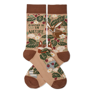 Two tan nature-themed crew socks crossed, showing a fox, rabbit, green leaves, red berries, mushrooms, and 