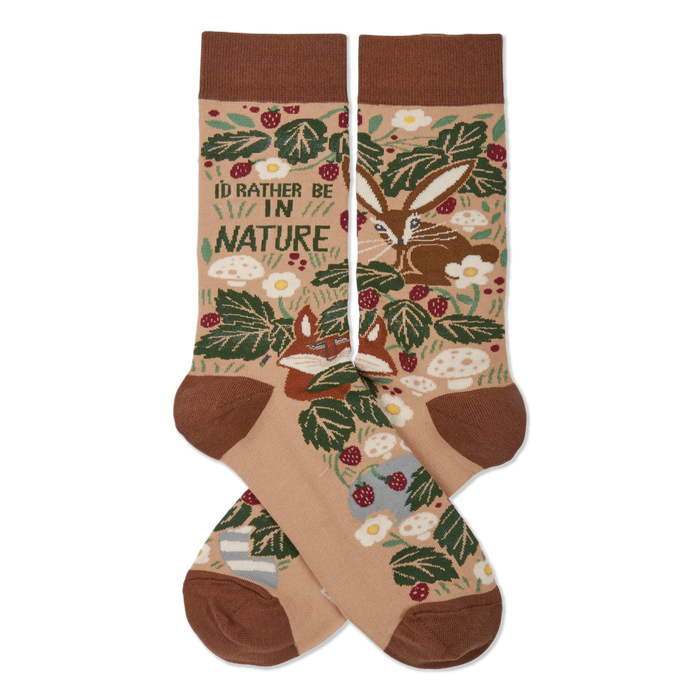 Two tan nature-themed crew socks crossed, showing a fox, rabbit, green leaves, red berries, mushrooms, and 