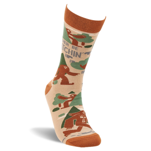 Single beige crew sock with rust orange cuff, heel, and toe. It features brown Sasquatch, green trees, and 