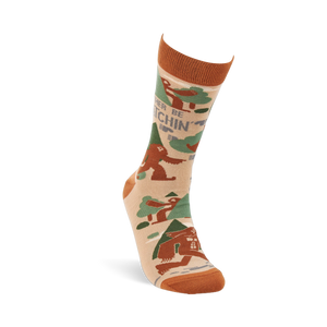 Single beige crew sock with rust orange cuff, heel, and toe. It features brown Sasquatch, green trees, and 