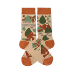 Pair of crew socks in beige, rust orange, and green, patterned with brown Sasquatch, trees, and "I'd Rather Be Squatchin'" text.