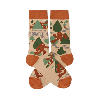 Pair of crew socks in beige, rust orange, and green, patterned with brown Sasquatch, trees, and "I'd Rather Be Squatchin'" text.