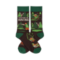 Pair of dark brown crew socks with green cuffs, heels, and toes. Pattern includes trees, deer, and hunters with rifles and bows. Text reads 'I'D RATHER BE HUNTING'.