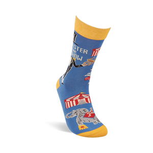 Single blue crew sock with yellow accents, angled. Shows ringmaster text, circus tent, balancing animal, and an elephant.