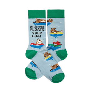 A pair of light blue crew socks with green cuffs, heels, and toes, featuring cartoon goats floating in colorful inner tubes and text.