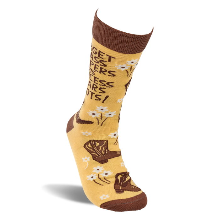 A single yellowish-tan crew sock, standing upright, with brown cowboy boots, white flowers, and the quote 