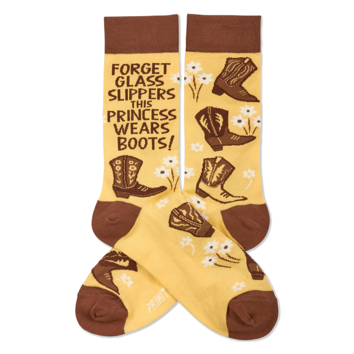 Pair of yellowish-tan crew socks with brown cuffs, heels, and toes. They feature brown cowboy boots, white flowers, and the quote 