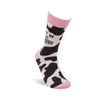 Single crew sock standing upright, showing black and white cow print with pink cuff, heel, and toe. "NOT IN THE MOOOOD!" text is visible on the leg.