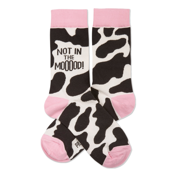 Pair of crew socks with black and white cow print, pink cuffs, heels, and toes. One sock reads 