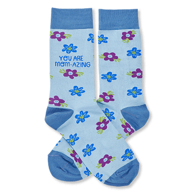 Pair of light blue crew socks with scattered blue and purple flowers. One sock reads "YOU ARE MOM-AZING" in green text.