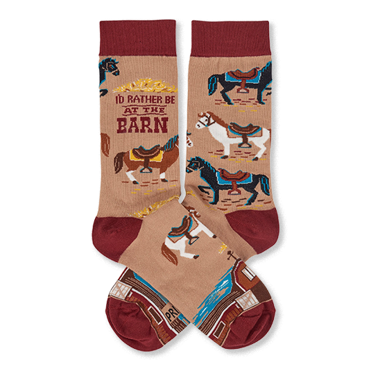 Pair of tan crew socks with reddish-brown cuffs, heels, and toes, featuring colorful horses, a barn, and 'I'd Rather Be At The Barn' text.