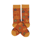 Pair of crew socks in rust orange with yellow cuffs, heels, and toes. Features scattered yellow, teal, and blue flowers. One sock reads 'FUN FACT... I DON'T CARE' in blue and teal text.