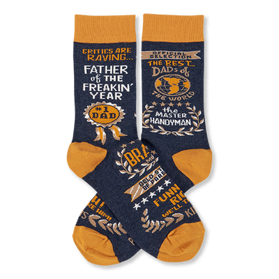 Pair of navy blue crew socks with mustard yellow accents, covered in gold and white text like 'Father Of The Year' and 'Master Handyman'.