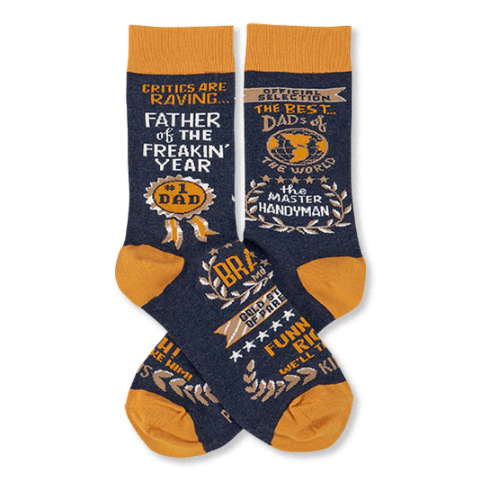 Pair of navy blue crew socks with mustard yellow accents, covered in gold and white text like 'Father Of The Year' and 'Master Handyman'.