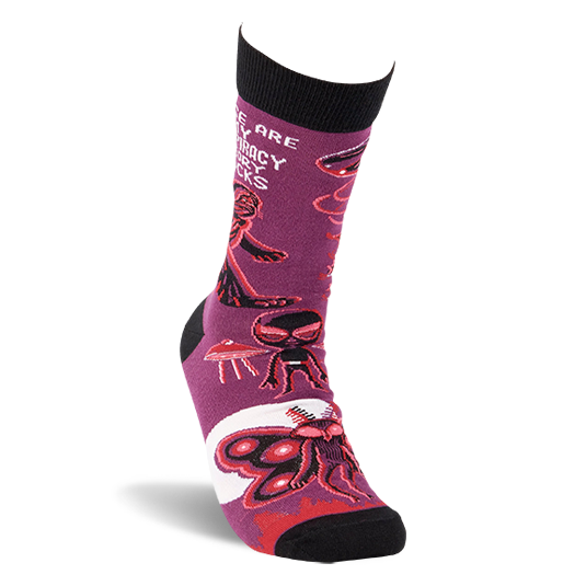 Single purple crew sock shown at an angle, featuring Mothman, alien, and UFO patterns with black cuff and toe.
