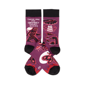 Pair of purple crew socks with black cuffs, heels, and toes, featuring Bigfoot, UFOs, aliens, and Mothman designs.