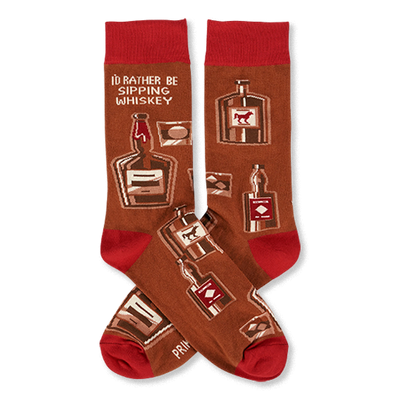Pair of crew socks in brown with red cuffs, heels, and toes. Patterned with whiskey bottles, glasses, and text 'I'D RATHER BE SIPPING WHISKEY'.