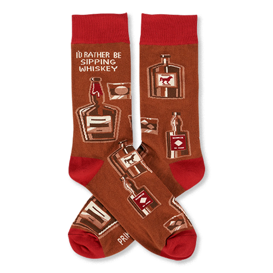 Pair of crew socks in brown with red cuffs, heels, and toes. Patterned with whiskey bottles, glasses, and text 'I'D RATHER BE SIPPING WHISKEY'.