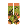 A pair of crew socks, olive green with orange accents. Features a dark green Bigfoot-like creature in a forest and 'Believe In Yourself' text.