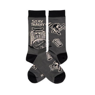 Pair of dark gray crew socks with black cuffs, heels, toes. Features raccoons, trash cans, and 'STAY TRASHY CREW' text.