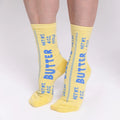 Yellow socks with blue text 'Butter' on a white background