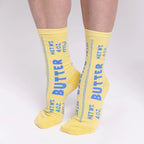 Yellow socks with blue text 'Butter' on a white background