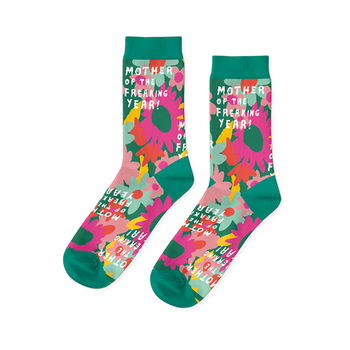 Pair of crew socks with pink, orange, and yellow flowers on a green background and teal cuffs, heels, toes.