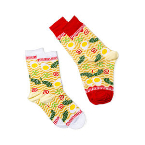 Ramen themed socks with wavy yellow noodles, fried eggs, green onions, and seaweed. Red & white cuffs feature a classic ramen