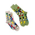 Two pairs of the same abstract art socks, one on a tan background and one on an olive green background, laid at an angle.