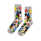 A pair of light grey crew socks with a vibrant abstract pattern, featuring black-outlined figures, colorful shapes, and green eyes.