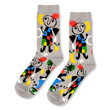 A pair of light grey crew socks with a vibrant abstract pattern, featuring black-outlined figures, colorful shapes, and green eyes.