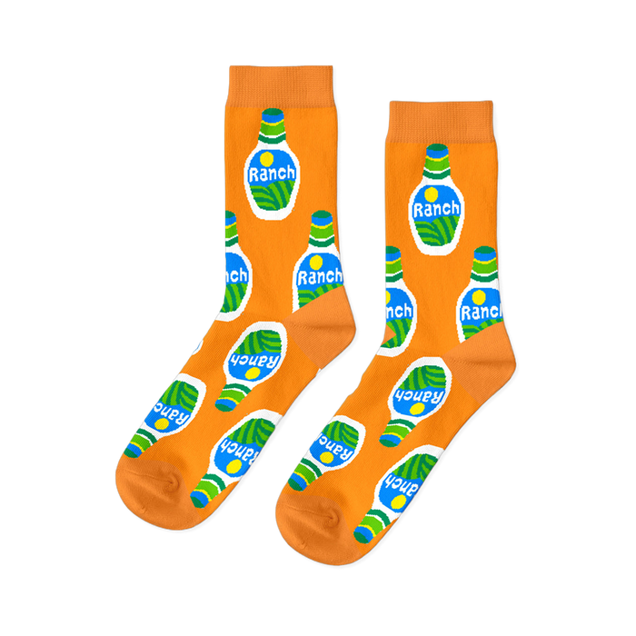 A pair of bright orange crew socks with an all-over repeating pattern of white ranch dressing bottles with green and blue accents.