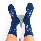 Person's legs raised against a white background wearing navy socks with text reading FATHER OF THE FREAKING YEAR.