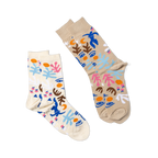Two pairs of abstract art-patterned socks. One pair is tan, the other is cream, both with blue figures, faces, and shapes.
