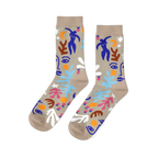 Pair of crew socks with an abstract Matisse-inspired pattern featuring blue figures, faces, stars, and leaves on a tan background.