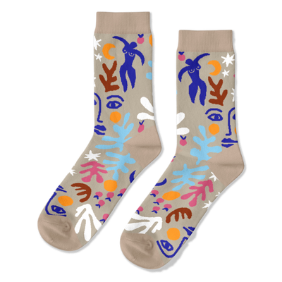 Pair of crew socks with an abstract Matisse-inspired pattern featuring blue figures, faces, stars, and leaves on a tan background.