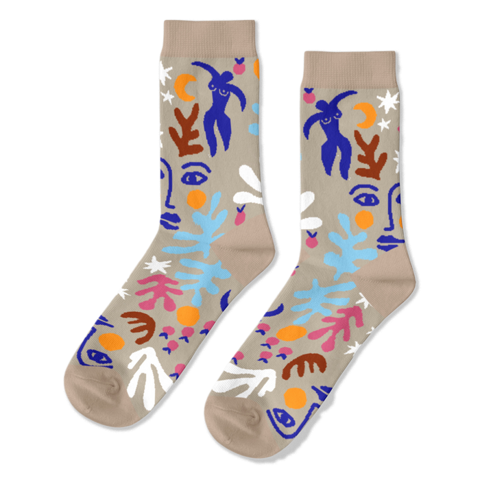 Pair of crew socks with an abstract Matisse-inspired pattern featuring blue figures, faces, stars, and leaves on a tan background.