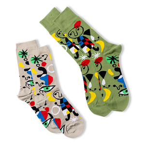 Two pairs of abstract art crew socks. One pair is olive green, the other light beige, both with colorful art patterns.