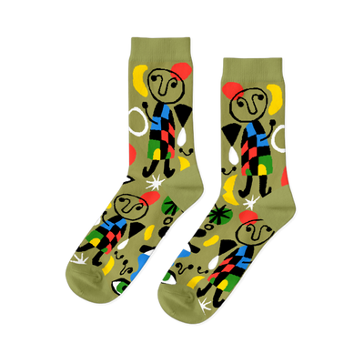 Pair of olive green crew socks with abstract art pattern, featuring stick figures, red stars, yellow moons, and colorful geometric shapes.