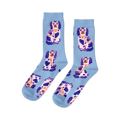 Pair of light blue crew socks, patterned with sitting white, dark blue, and purple Staffordshire dog figurines wearing gold chains.