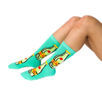 A person's lower legs and feet, wearing the aqua Top Chica bottle crew socks, sitting on a white surface.