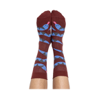A person's bare legs wearing reddish-brown snake pattern crew socks, shown from the soles up, against a plain background.