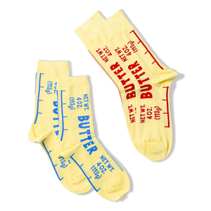 Three butter-themed ankle socks against a black background, two with blue text stacked on left, one with red text angled on right.