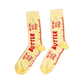 A pair of light yellow ankle socks printed with 'BUTTER' and 'NET WT. 4 OZ. (113g)' in red text, mimicking a stick of butter wrapper.