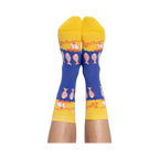 A person's feet wearing the blue and yellow anchovy crew socks, with the pattern of fish and text clearly visible.
