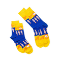 Two pairs of anchovy crew socks, one lying flat and one folded, showing the blue and yellow design with fish and sailboats.