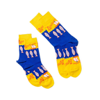 Two pairs of anchovy crew socks, one lying flat and one folded, showing the blue and yellow design with fish and sailboats.