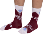 Person wearing deep red Kosher Salt crew socks, stretched over visible lower legs, showing the full design.